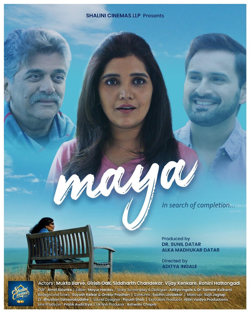 Poster for the film Maya, showing three cast members against a coastal sky above a woman seated alone on a bench